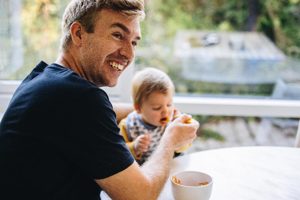a man gives a meal to a small kid